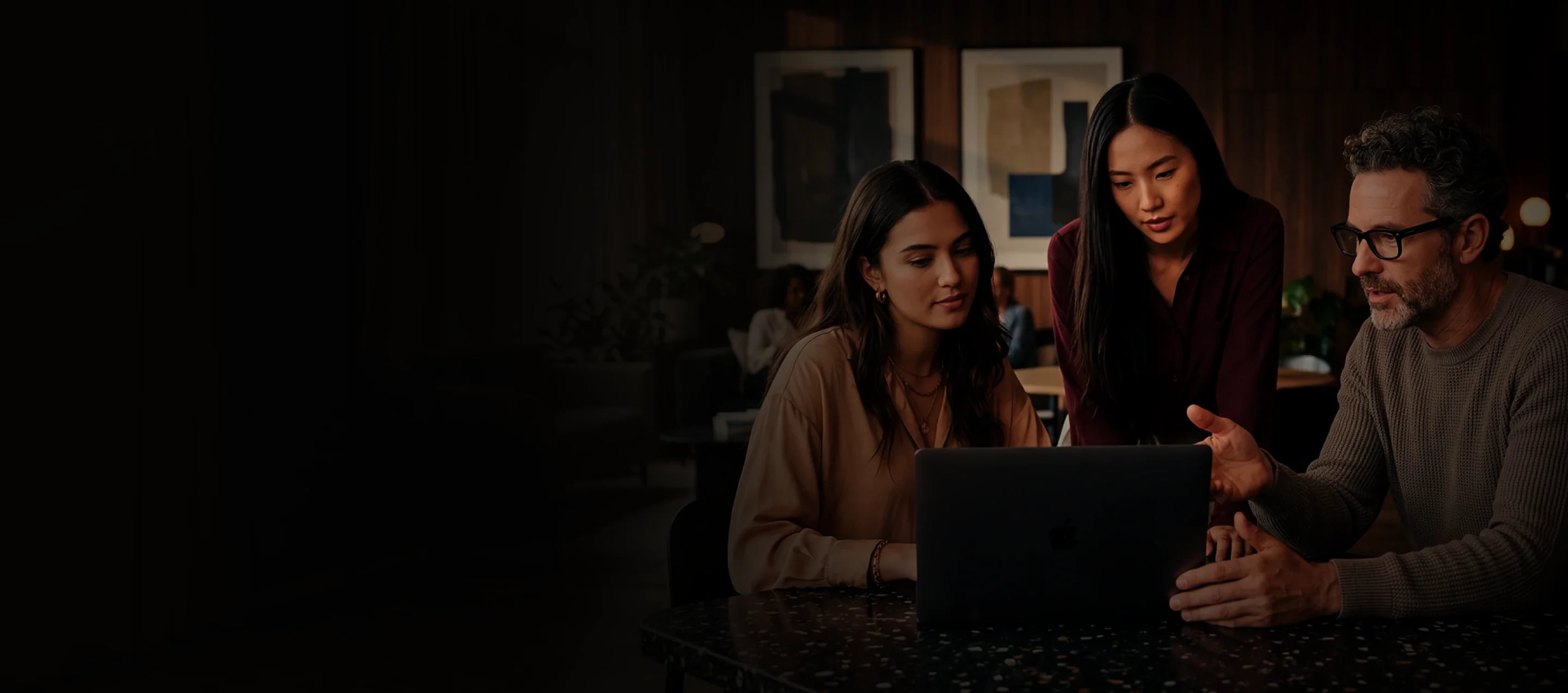 Three colleagues reviewing a webinar registration page together on a laptop
