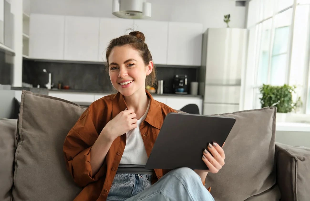 A person relaxed on a couch with a laptop, building their demo funnel with EasyWebinar AI