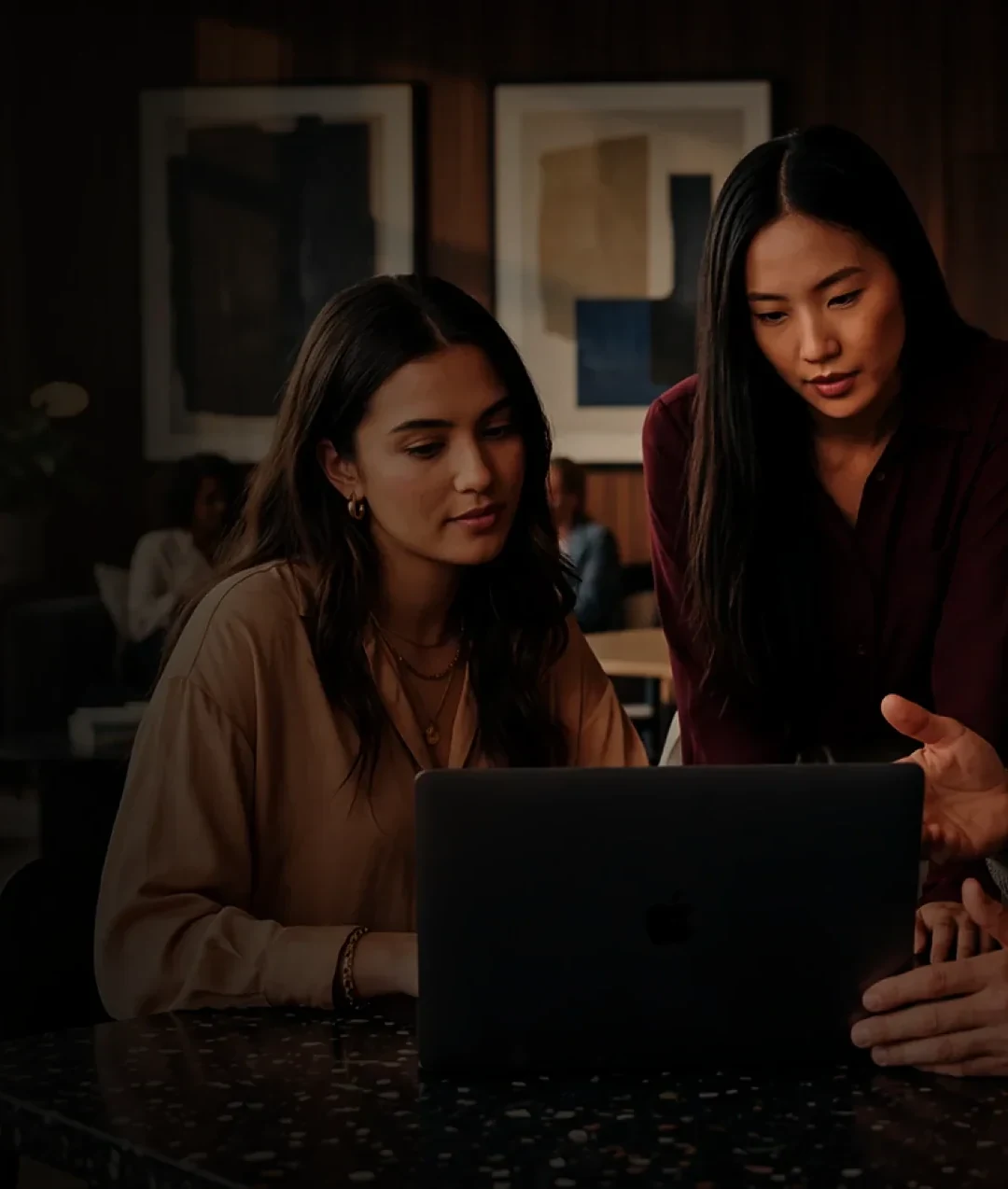 Two agency marketers reviewing a campaign on a laptop