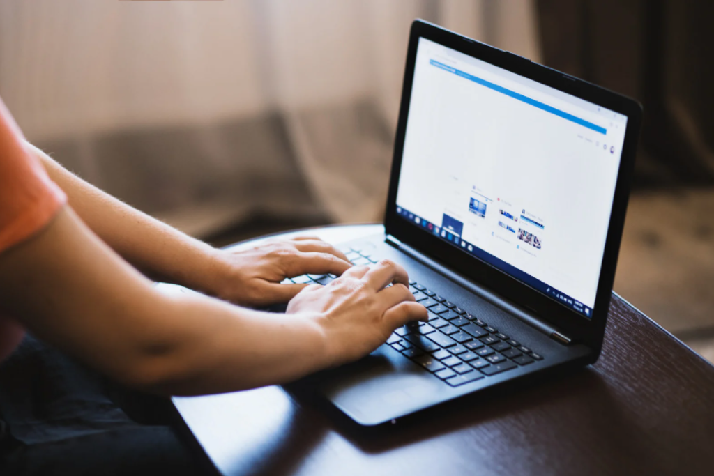 Man typing keywords in a search engine on a laptop